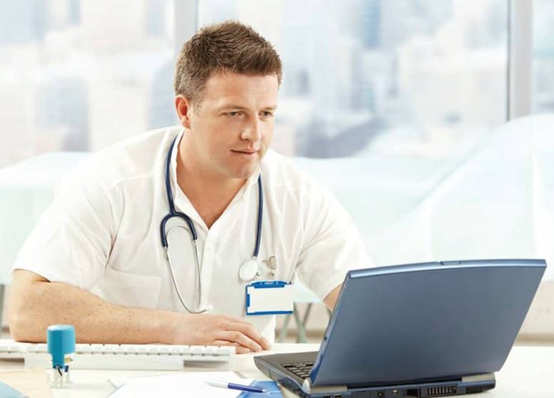 Male doctor viewing laptop screen